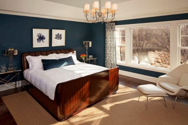 Хорошо оформленная спальня со стеной темно-синего цвета и боковым стулом.