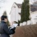 A person checking documents in front of a house