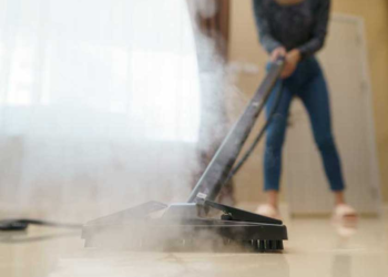 A person cleaning the floor with steam Cleaner