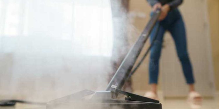 A person cleaning the floor with steam Cleaner