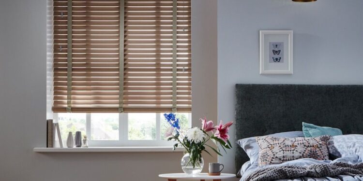 A window in the bedroom covered with blind