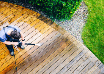 man cleaning terrace with a pressure washer