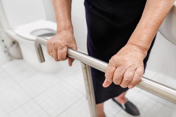 An elderly holding Safety rails in the bathroom