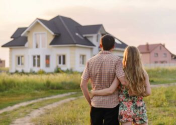 Couple standing in front of house