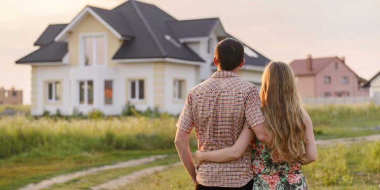 Couple standing in front of house