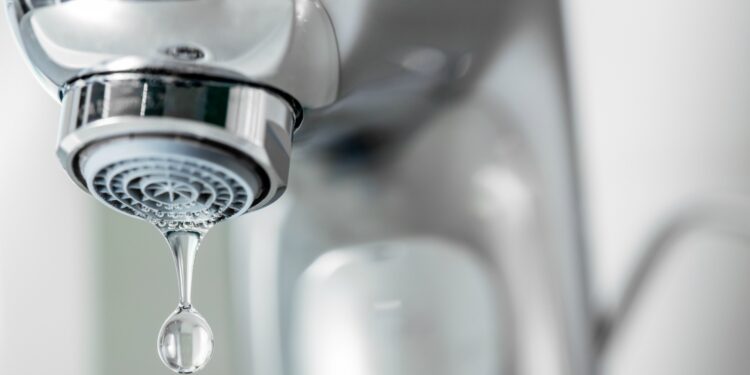 Tap closeup with dripping water-drop. Water leaking, saving concept.