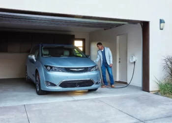 Man Using Home Charging Station to Charge Electric Car