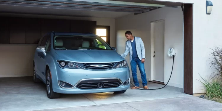 Man Using Home Charging Station to Charge Electric Car