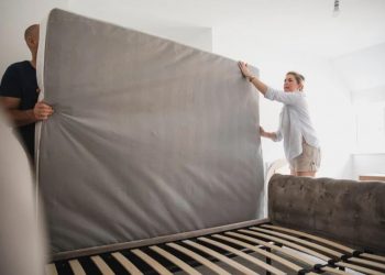 guy and girl holding matress