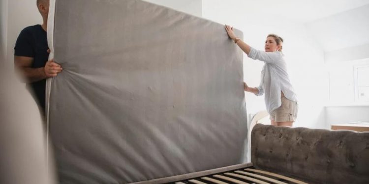 guy and girl holding matress