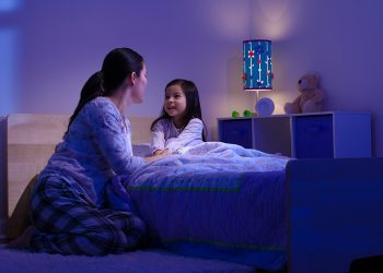 Mother talking with her child before bedtime, smiling.
