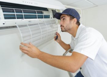 portrait of mid-adult male technician repairing air conditioner