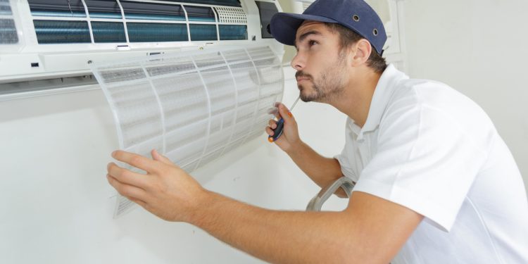 portrait of mid-adult male technician repairing air conditioner