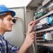 Technician Examining Fusebox With Multimeter Probe