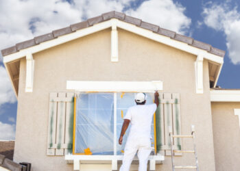 a men doing painting on wall