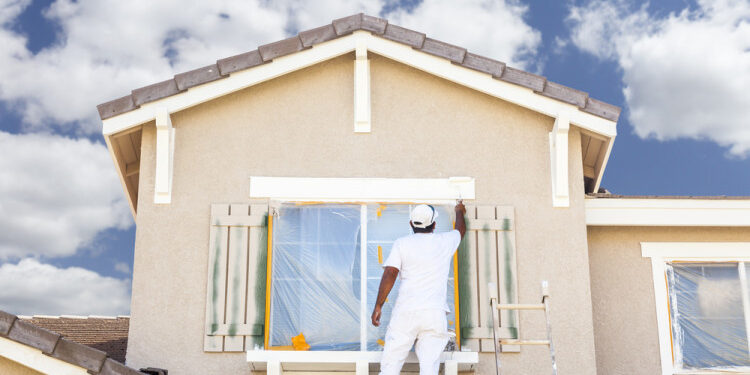 a men doing painting on wall