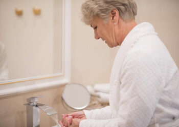a lady cleaning her hand in washroom