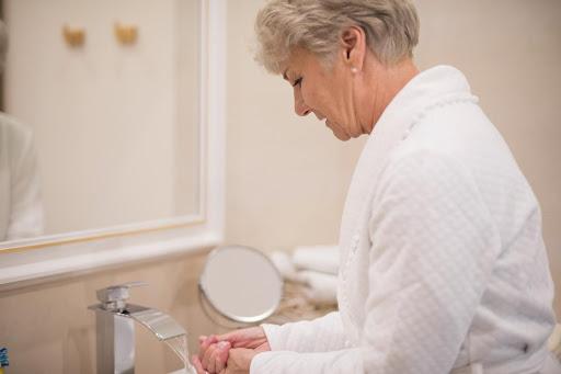 a lady cleaning her hand in washroom